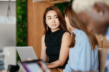 Asian woman discussing business plan with diverse colleagues - executive assistant jobs