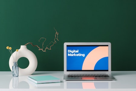 Silver Laptop on White Desk with Digital Marketing Label on Screen - job courses online