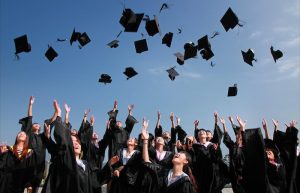 Newly Graduated People Wearing Black Academy Gowns Throwing Hats Up in the Air - backyard graduation party ideas