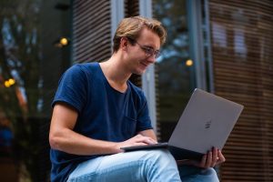 AI side hustles featured image man smiling at laptop