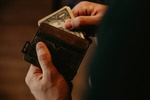 person opening wallet with cash money - strategic cash reserves