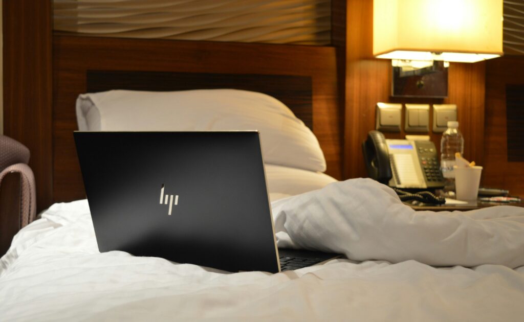 productive while working from a hotel laptop on bed 