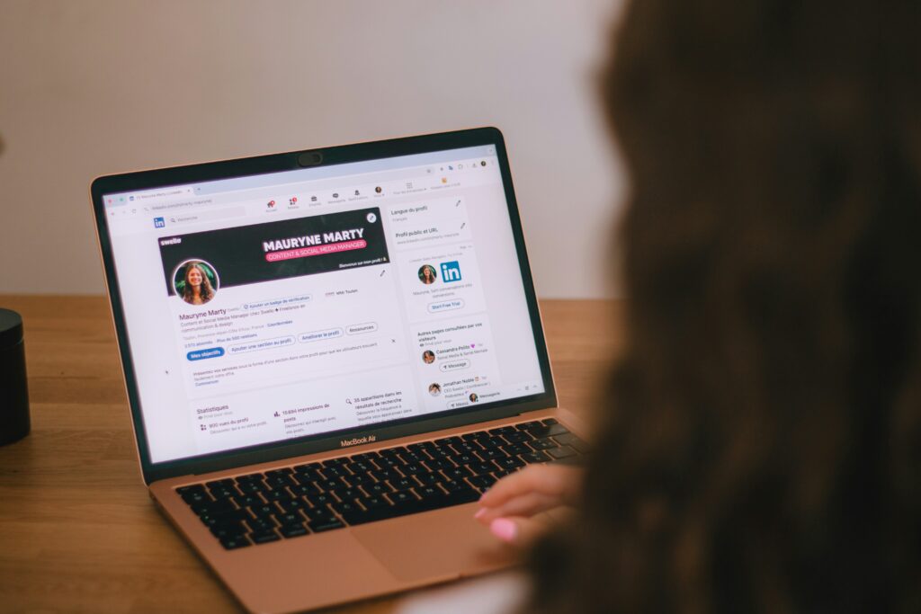 Person using laptop on LinkedIn profile build a personal brand on linkedin