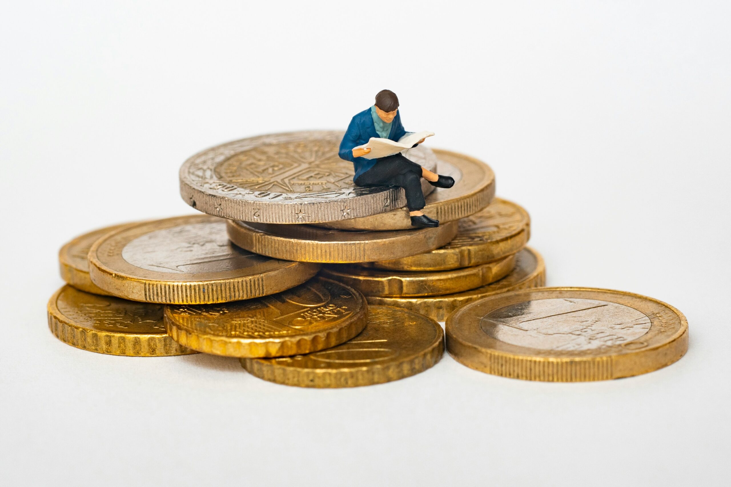man sitting on a pile of coins money cash index funds for beginners