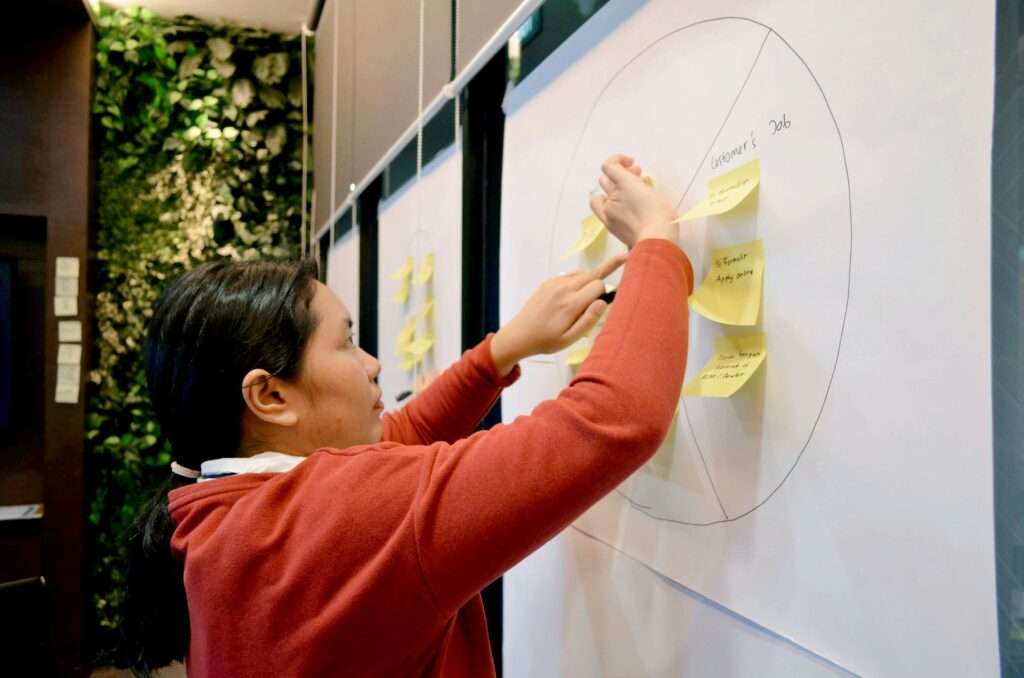 woman working on whiteboard how to build a brand identity for small business