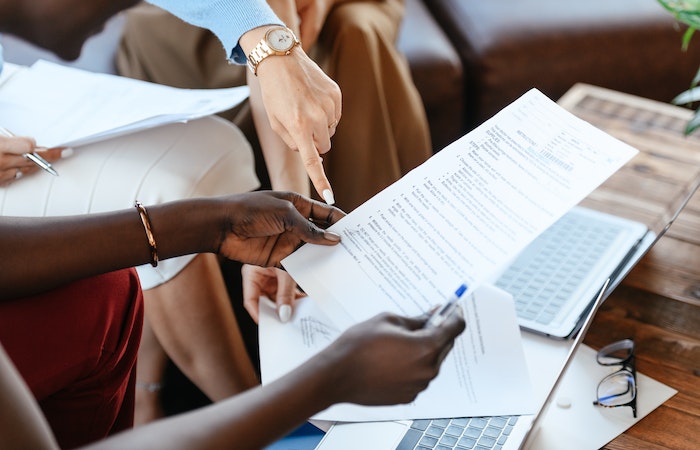 Businesswomen checking information in documents - resignation letter for designer