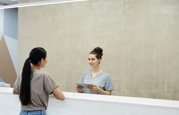 A Receptionist Smiling at a Person - how many jobs are in consumer services