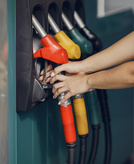 Crop woman taking refueling pistol gun - best paying jobs in basic industries
