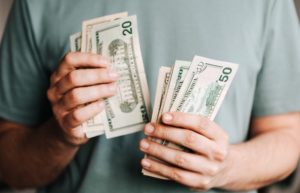 Crop man counting dollar banknotes - how to get a raise