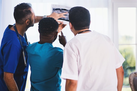hree Person Looking at X-ray Result - how to become an OB GYN