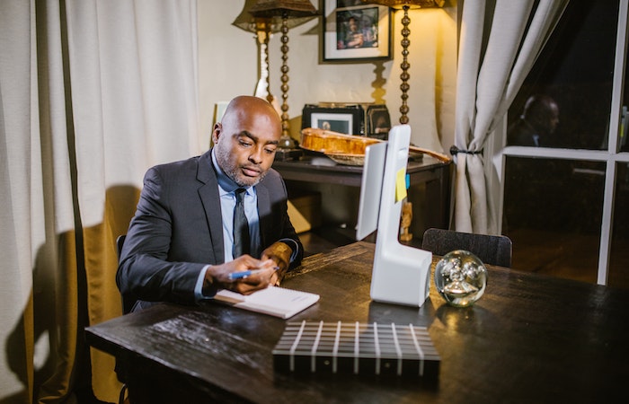 Man sitting in chair in front of computer taking notes - professional training courses