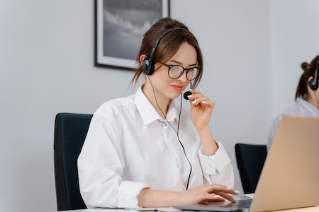 Photo of a Woman in a White Shirt Holding the Microphone on Her Headset - what is a registered agent for a llc