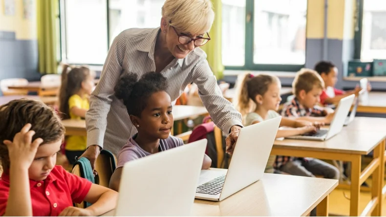 teacher teaching in classroom with classroom supplies