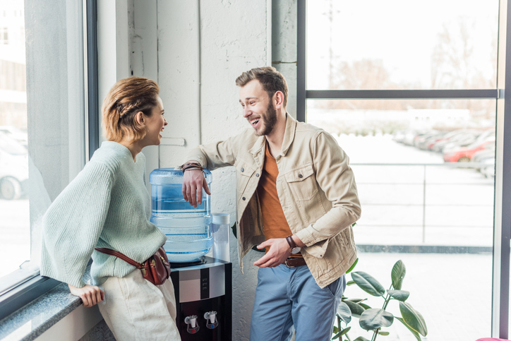 casual businessman and woman talking and laughing in loft office how to start an airbnb