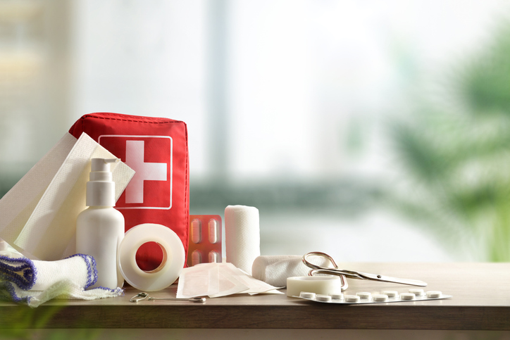 Emergency home kit on wooden table and warm room background. Horizontal composition. Front view. first aid kit