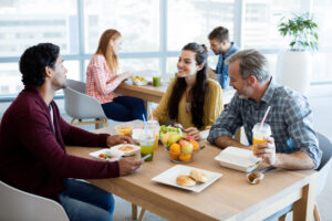 Creative business team discussing while having meal in office small business week