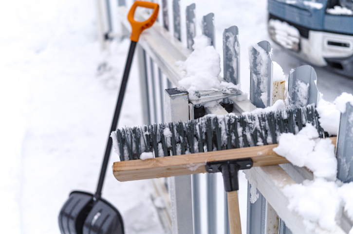 winter facilities management snow removal from sliding gate mechanism with brush, winter scene