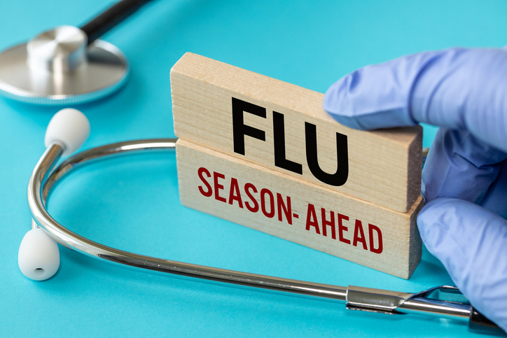 Flu Season ahead symbol. Flu Season ahead concept word on wooden blocks. Doctor's hand. Blue background and stethoscope. Medicine and Flu Season ahead concept. close up flu season at work