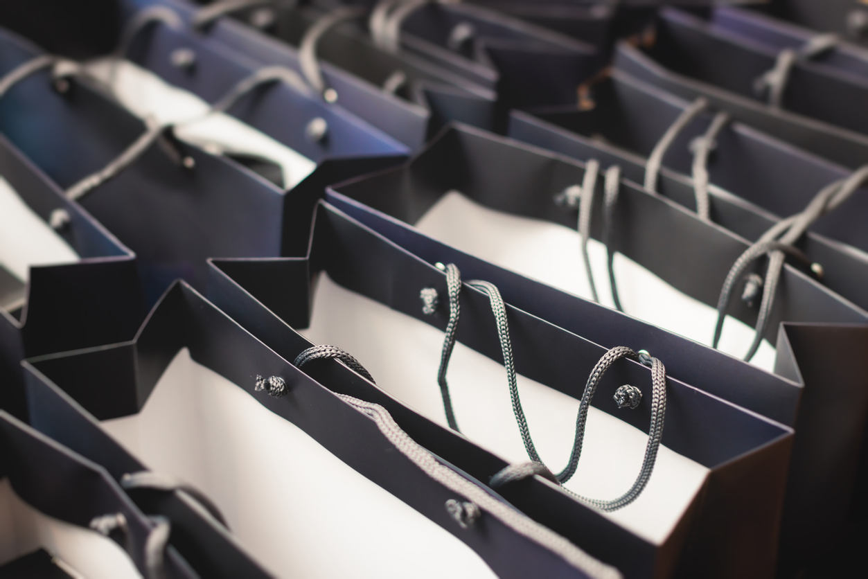Corporate gifts and souvenirs for company employees, gift bag package for conference participants before start, presentation of corporate gifts, gift giving at office work, dark blue paper bag bunch promo items for small businesses