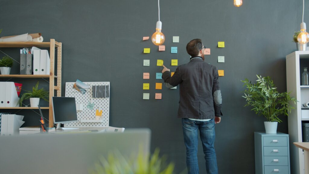 how to set up a productivity wall man putting up post it notes